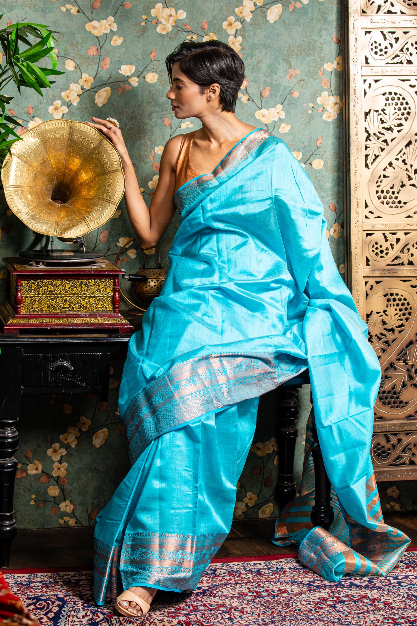 Woman in a baby blue raw silk saree with copper accents, ideal for festive occasions. | Urbane Essence