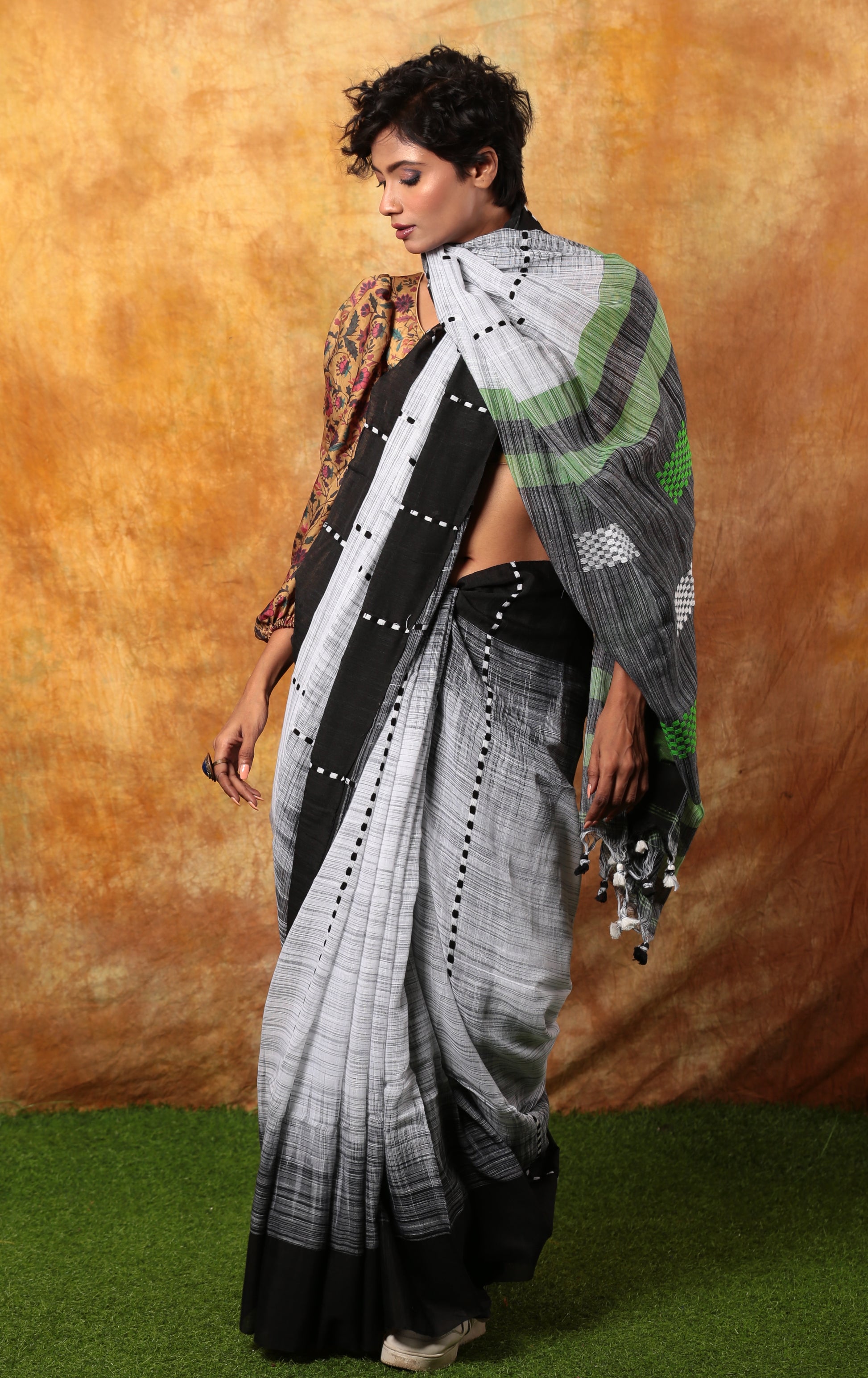 Model in a black and white Bengal Khadi saree with green accents, suitable for corporate events | Urbane Essence