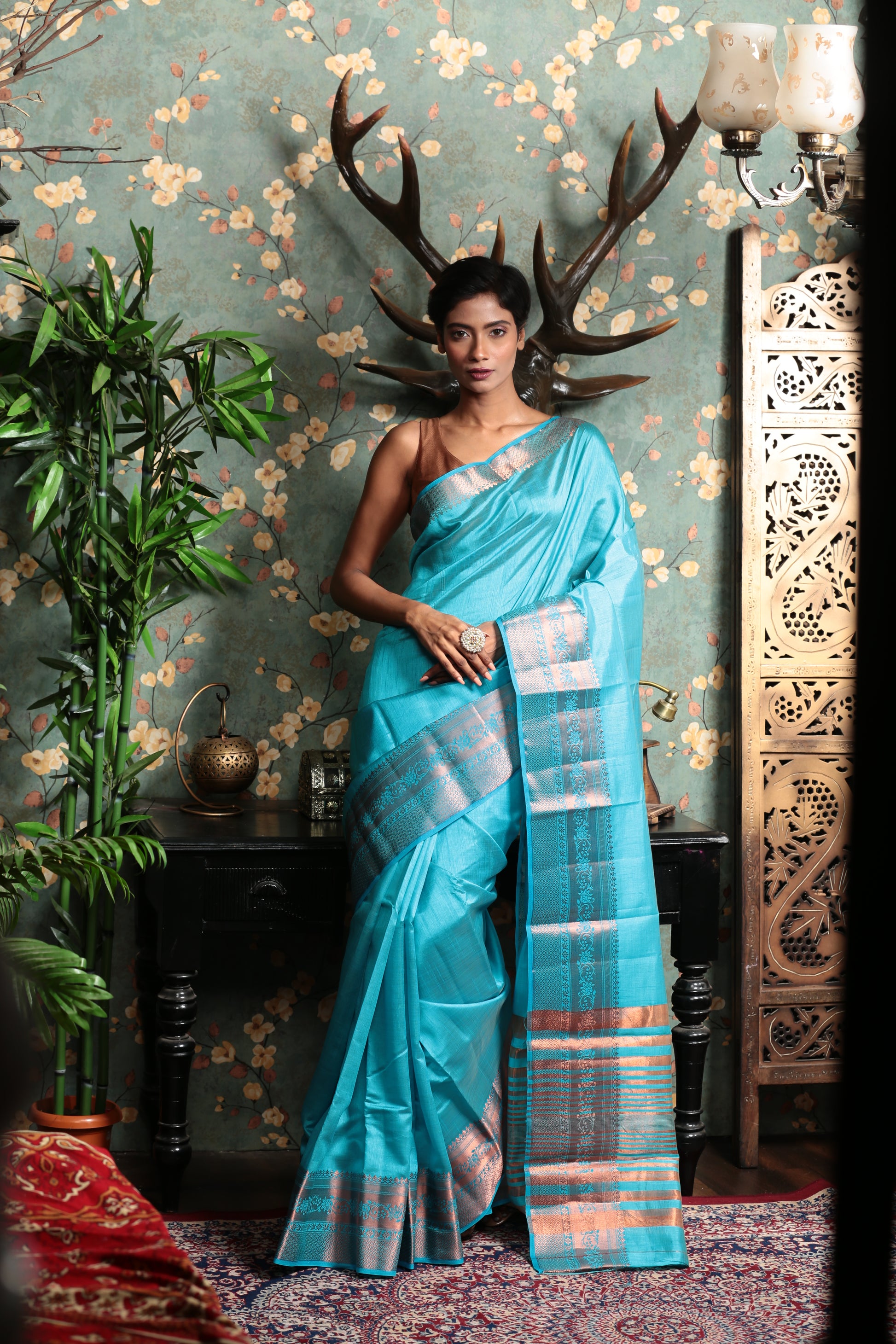 Model in a blue raw silk saree with a patterned pallu, ideal for temple wear. | Urbane Essence