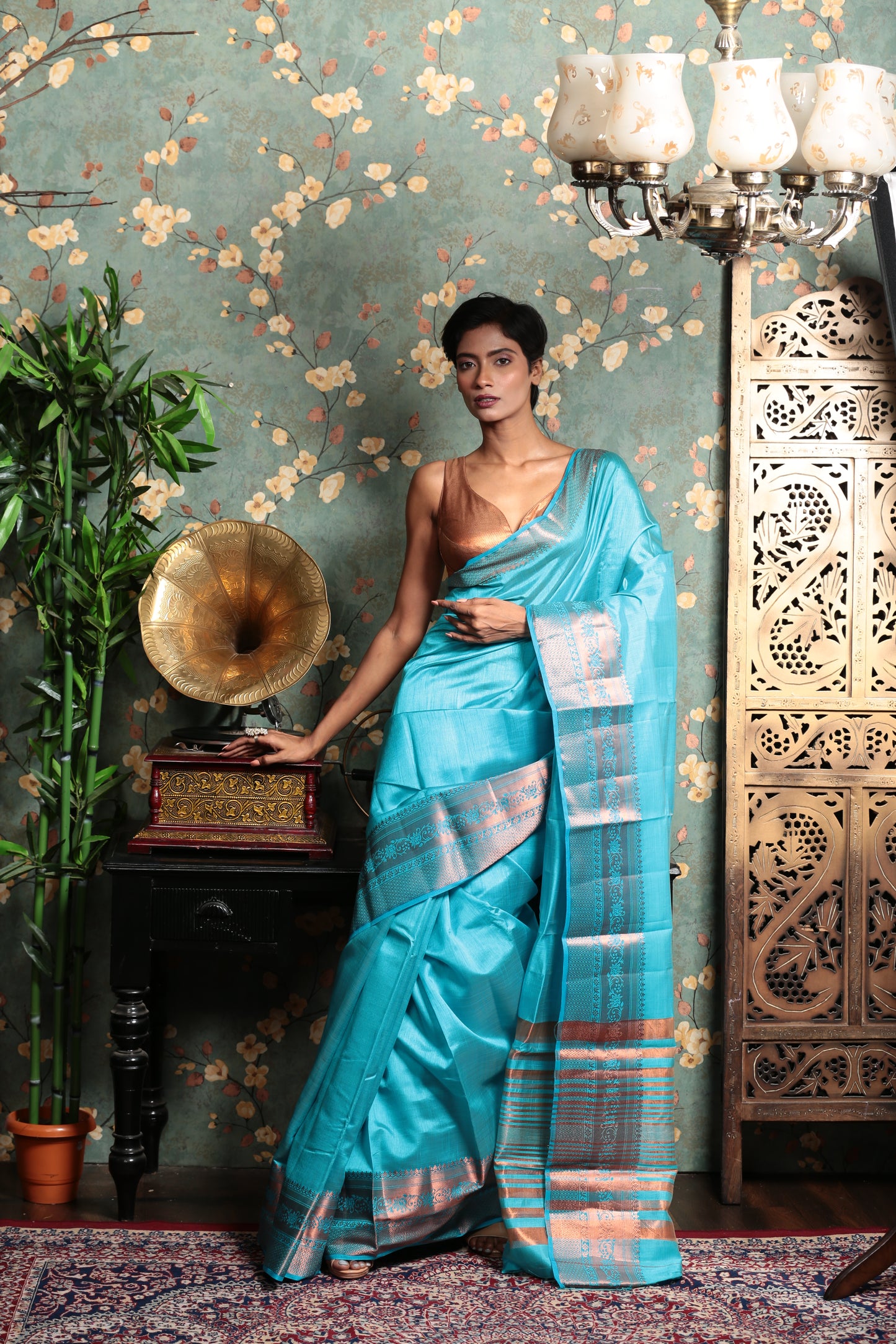 Model in a blue raw silk saree with Harappan-inspired floral pallu, perfect for temple wear. | Urbane Essence
