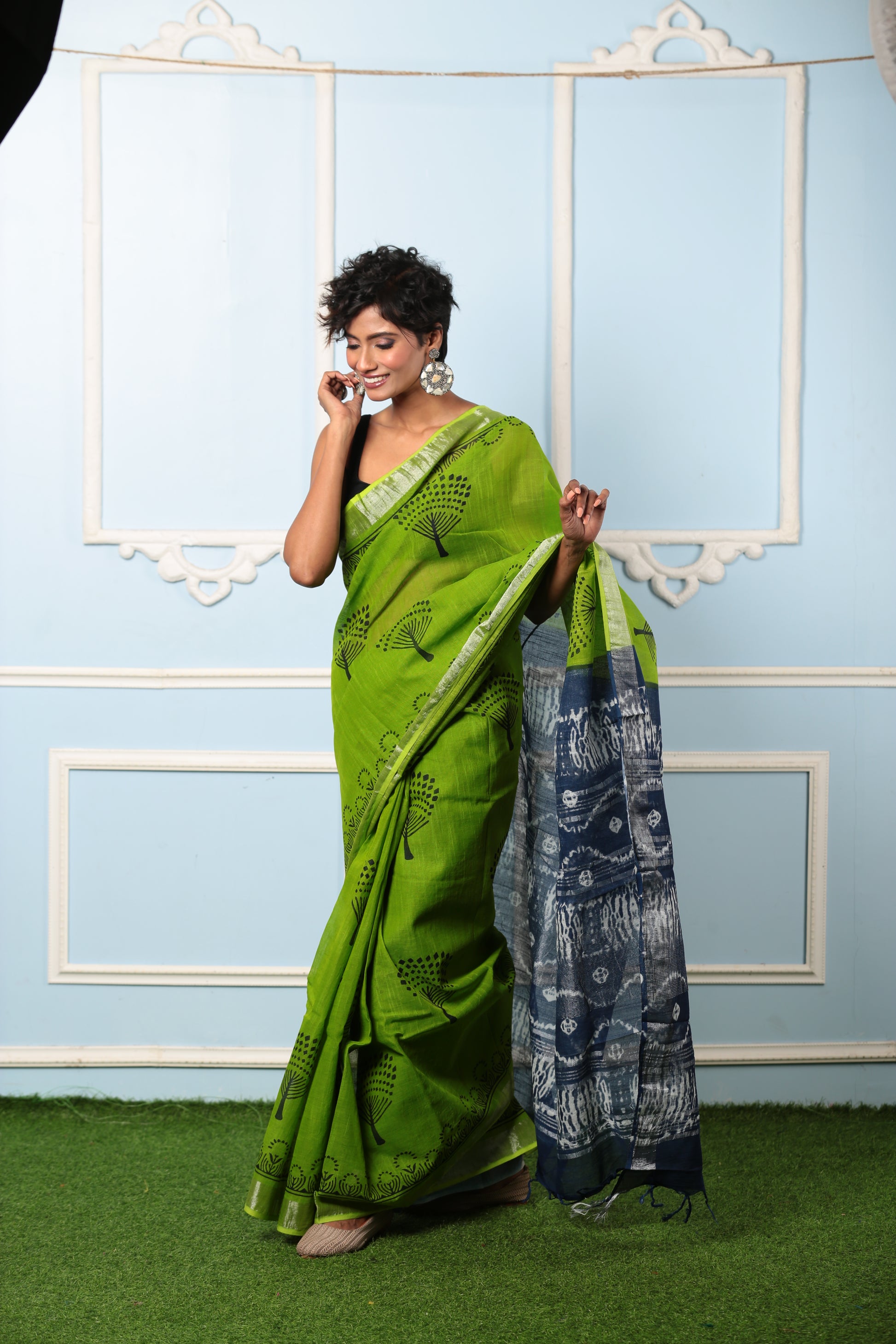 Woman in a parrot green Jaipur cotton saree with black motifs and a dark grey patterned pallu, suitable for professional or celebratory wear | Urbane Essence