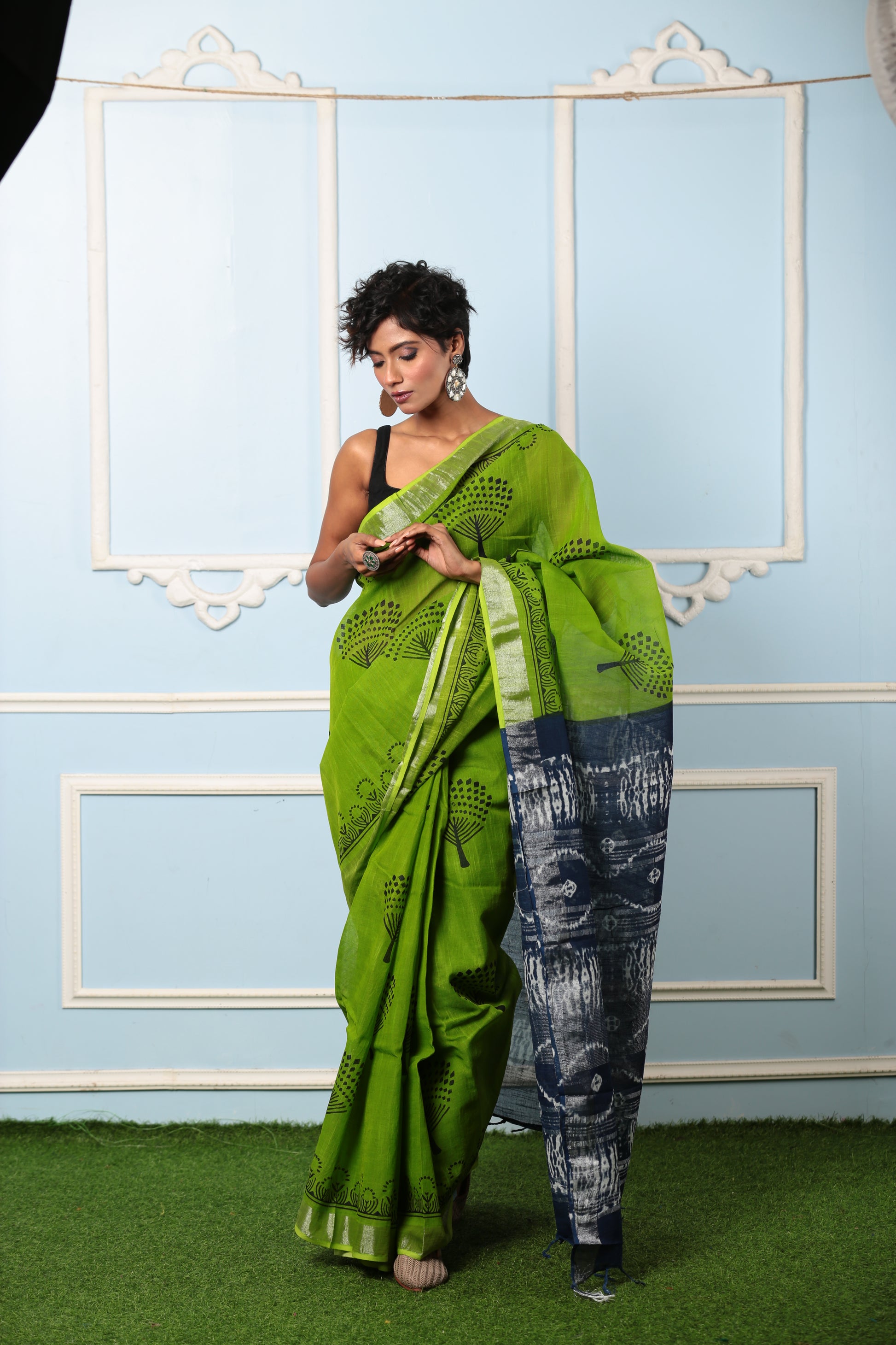 Woman in a parrot green Jaipuri cotton saree with dark grey pallu, suitable for professional or celebratory wear | Urbane Essence