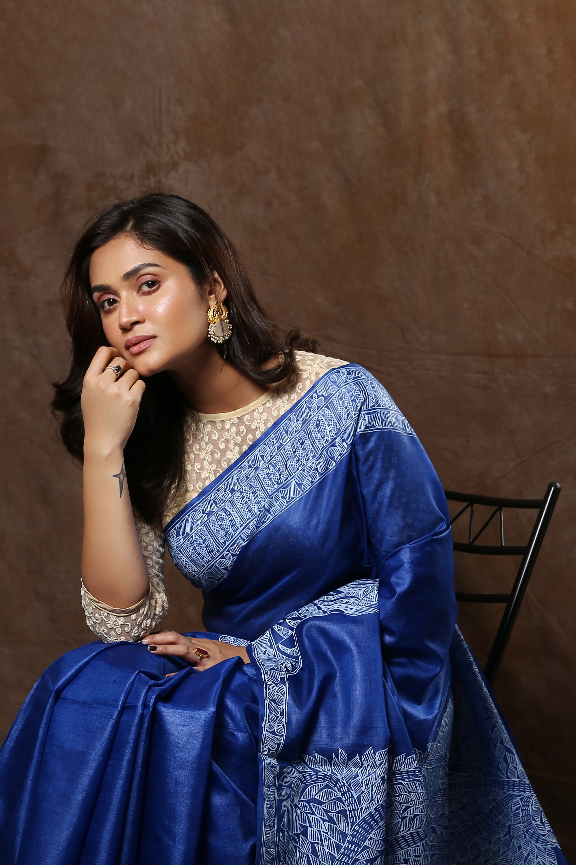 Woman in a blue Tussar saree with white Madhubani art, suitable for festive occasions. | Urbane Essence