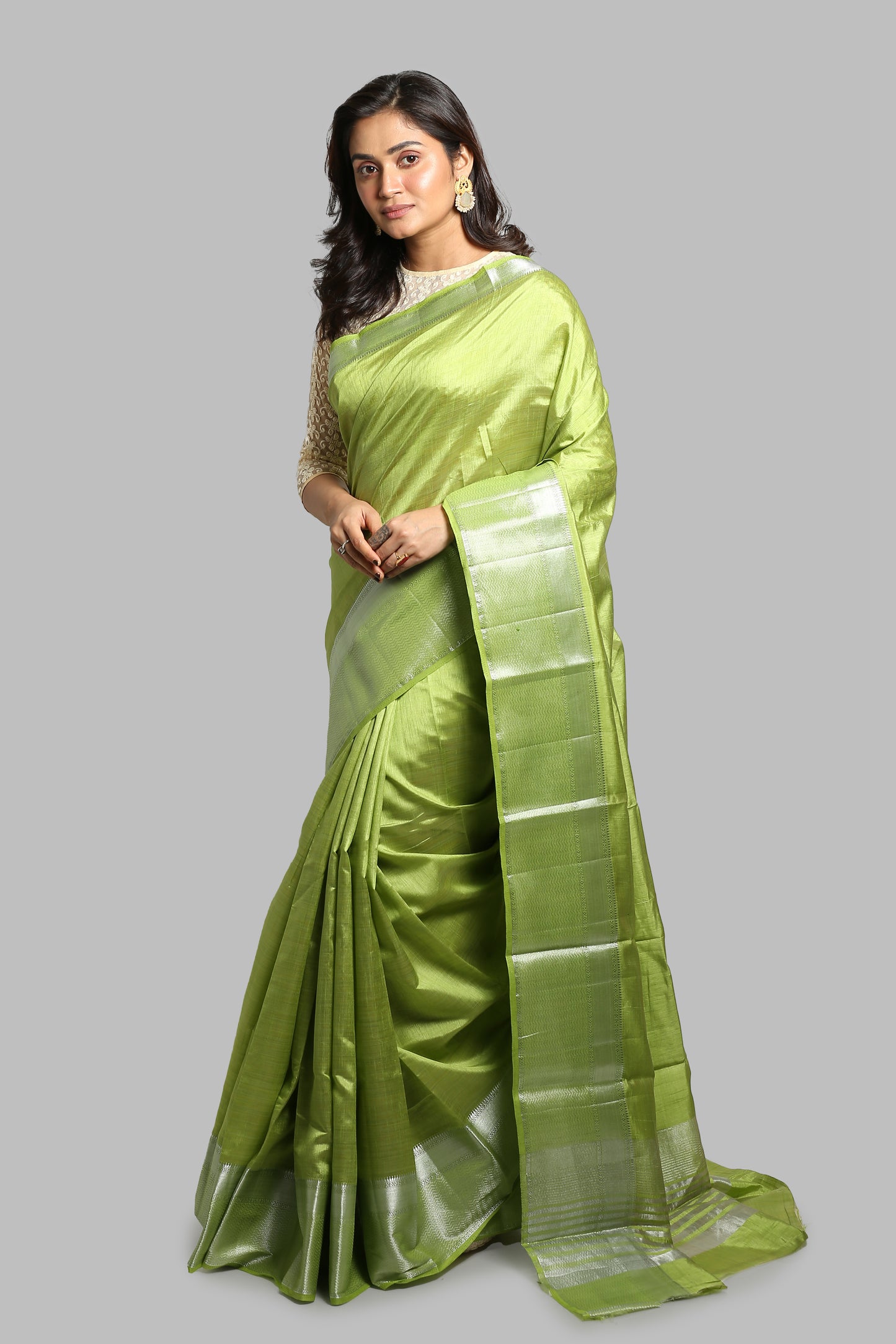Green raw silk saree with silver zari border, traditional Banarasi style, perfect for festive wear | Urbane Essence