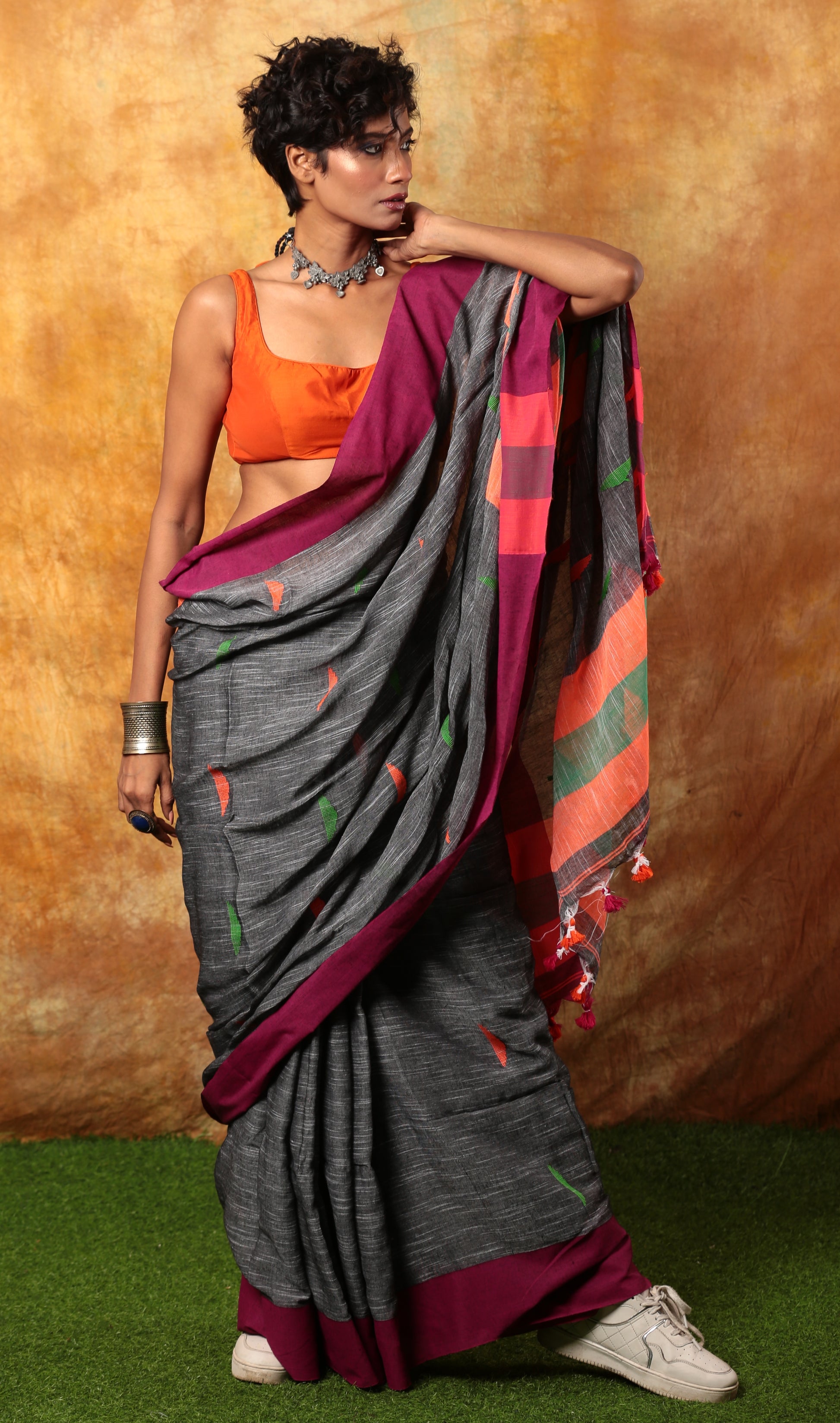 Assam Khadi saree: grey with magenta border, subtle patterns, paired with an orange blouse. Perfect for work. | Urbane Essence
