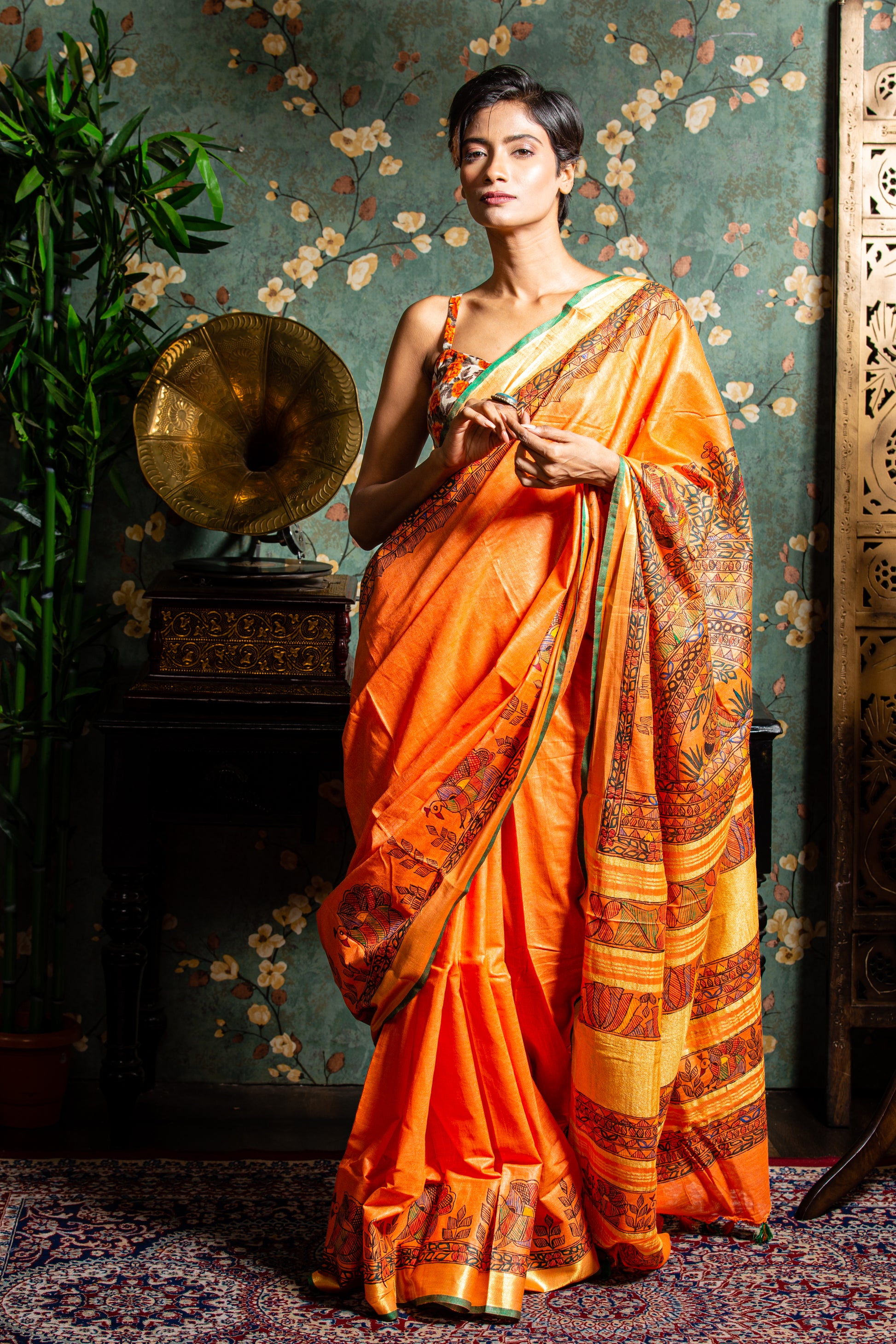 Woman in bright orange Tussar silk Madhubani saree, perfect for a glamorous evening | Urbane Essence