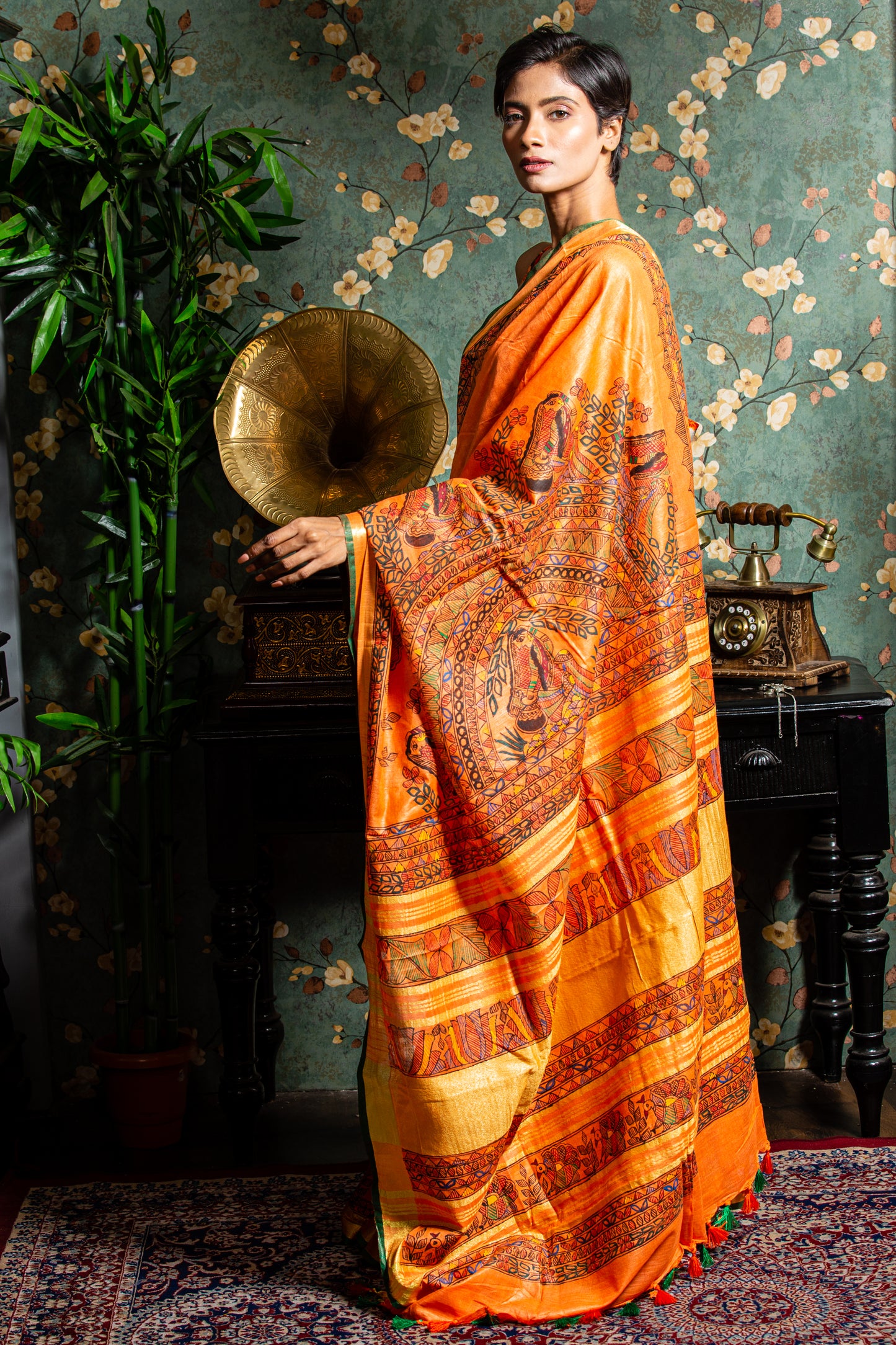Woman in bright orange Tussar silk Madhubani saree, perfect for a glamorous evening | Urbane Essence