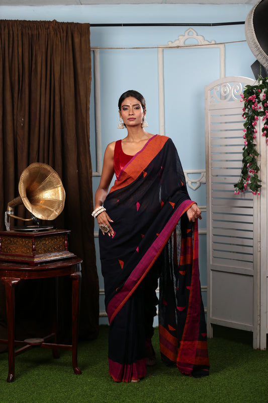 Model in black Assam Khadi saree with multicolor patches, broad purple border, and red blouse for summer events | Urbane Essence