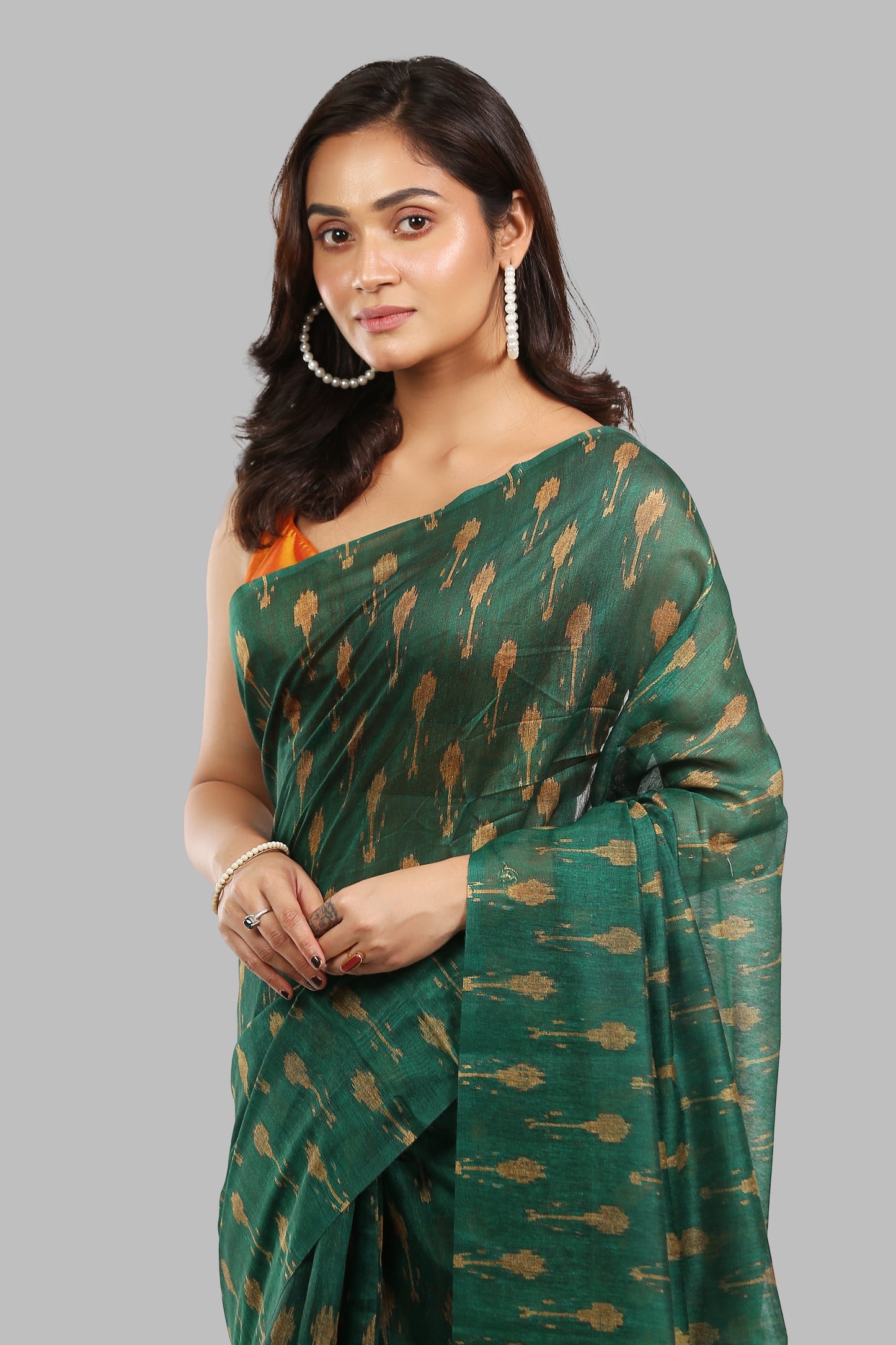 Deep green raw silk saree with all-over golden patterns, ideal for traditional occasions. | Urbane Essence