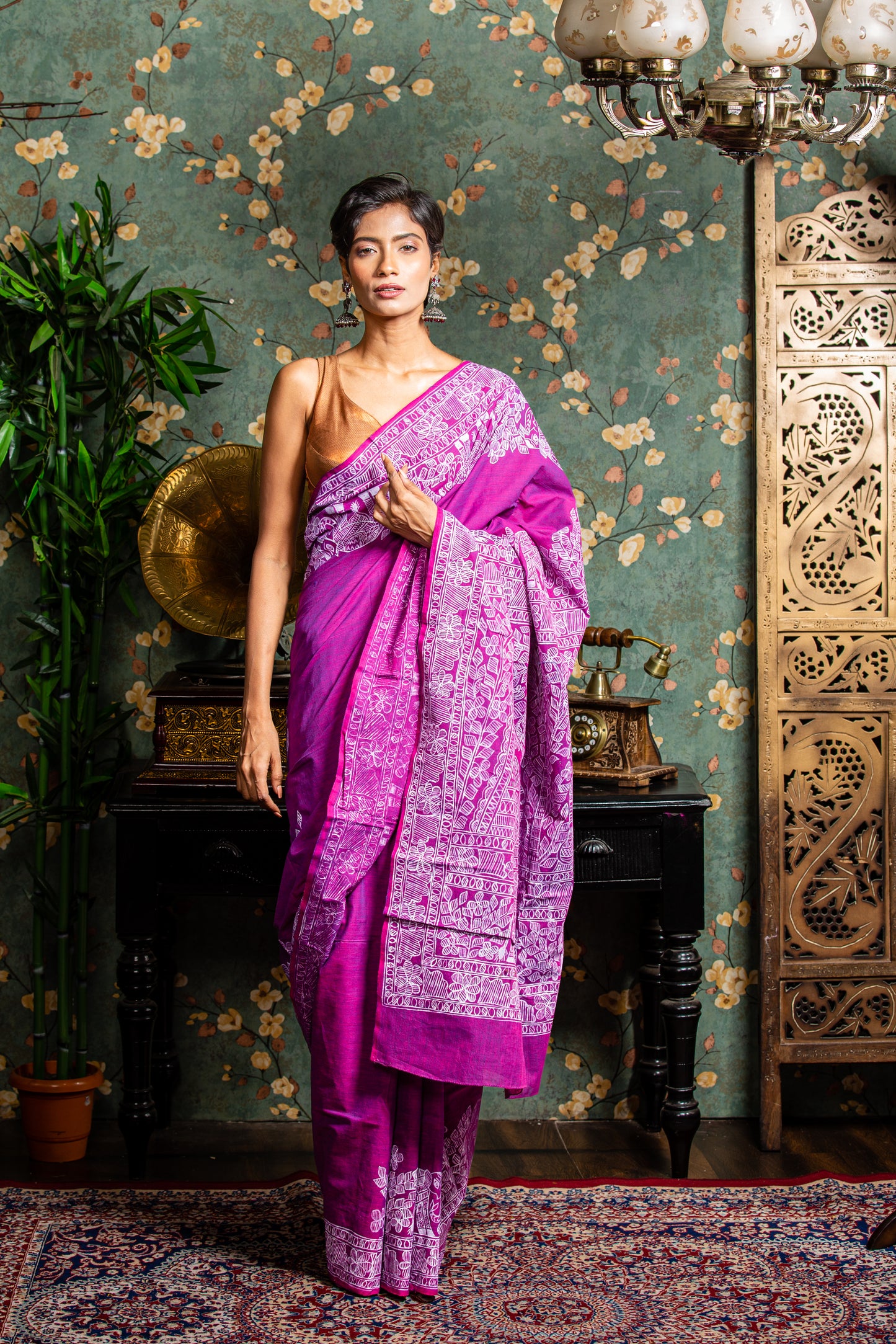 Woman in a magenta Tussar silk saree with white Madhubani painting on border and pallu, perfect for cultural events | Urbane Essence