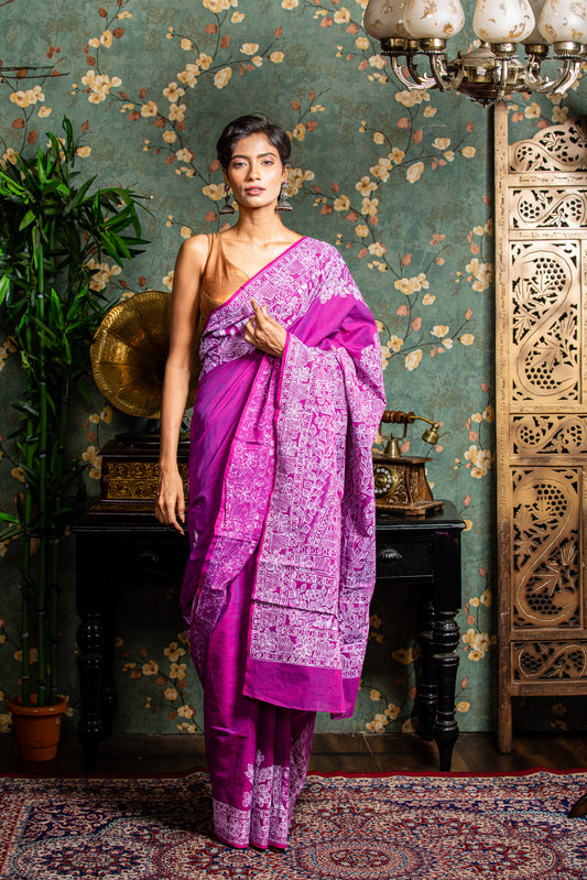 Woman in a magenta Tussar silk saree with white Madhubani painting on border and pallu, perfect for cultural events | Urbane Essence