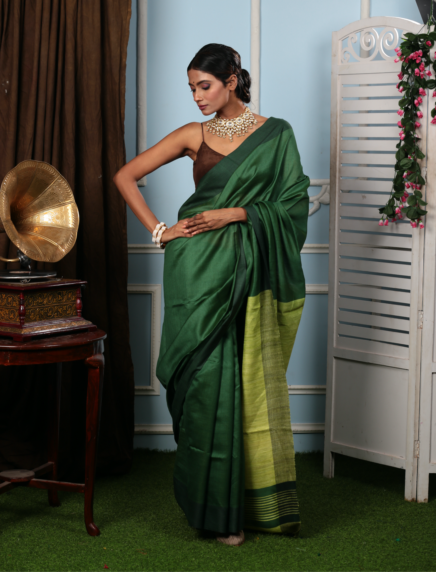Elegant woman in a dark green Tussar silk saree with a lime green border, perfect for festive occasions | Urbane Essence
