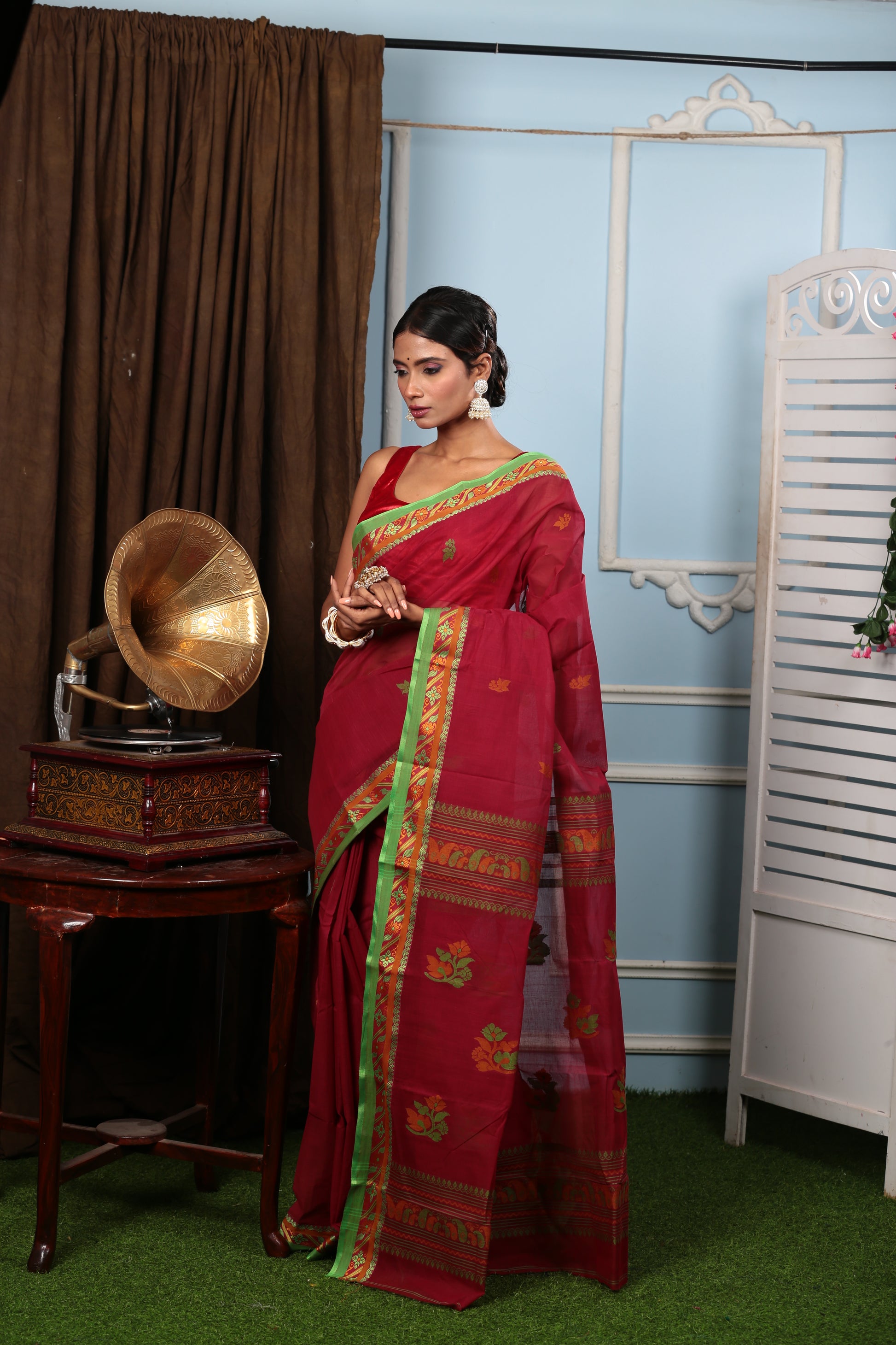 Elegant red Tant saree with green border, floral pallu, and sparse patterns, perfect for festive occasions | Urbane Essence