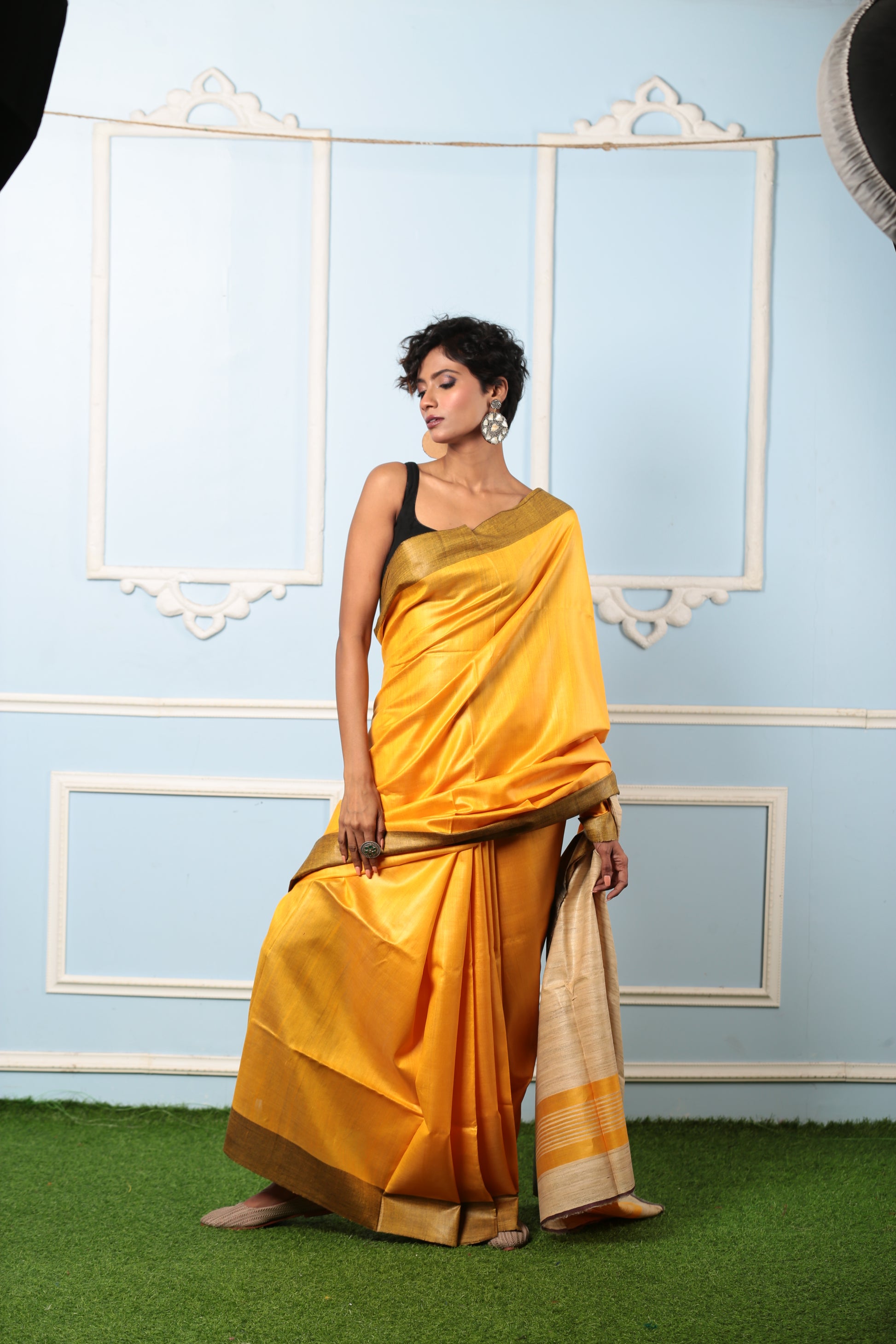 Model in a bright yellow Purulia Tussar silk saree with a black border, perfect for day occasions | Urbane Essence