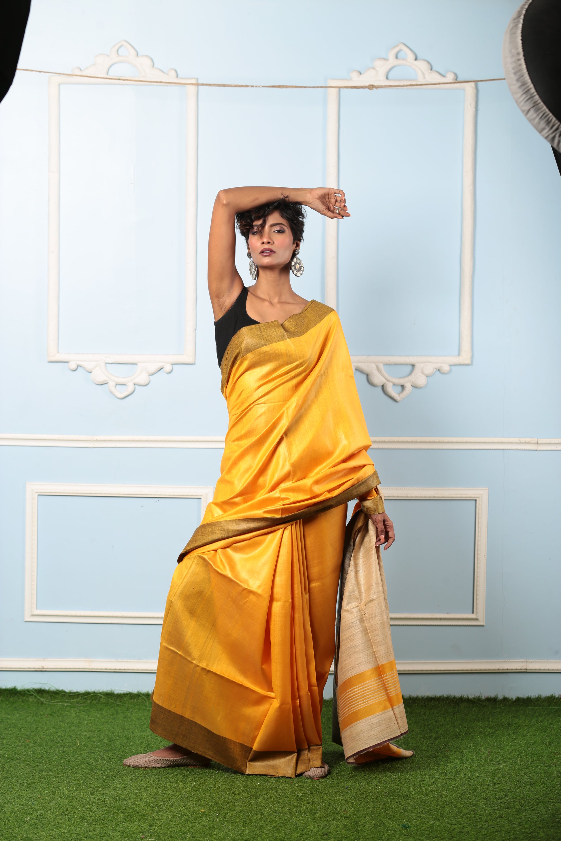 Model in a vibrant yellow Tussar silk saree with brown border, perfect for day occasions. | Urbane Essence