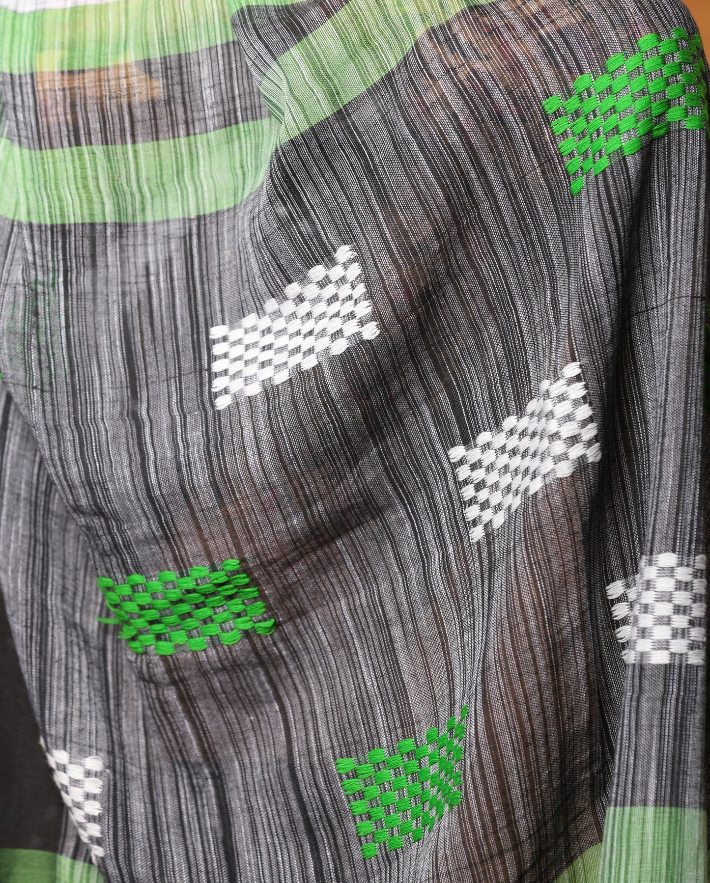 Assam Khadi saree in white and black with green accents, traditional patterns, and tassels, perfect for summer mornings | Urbane Essence