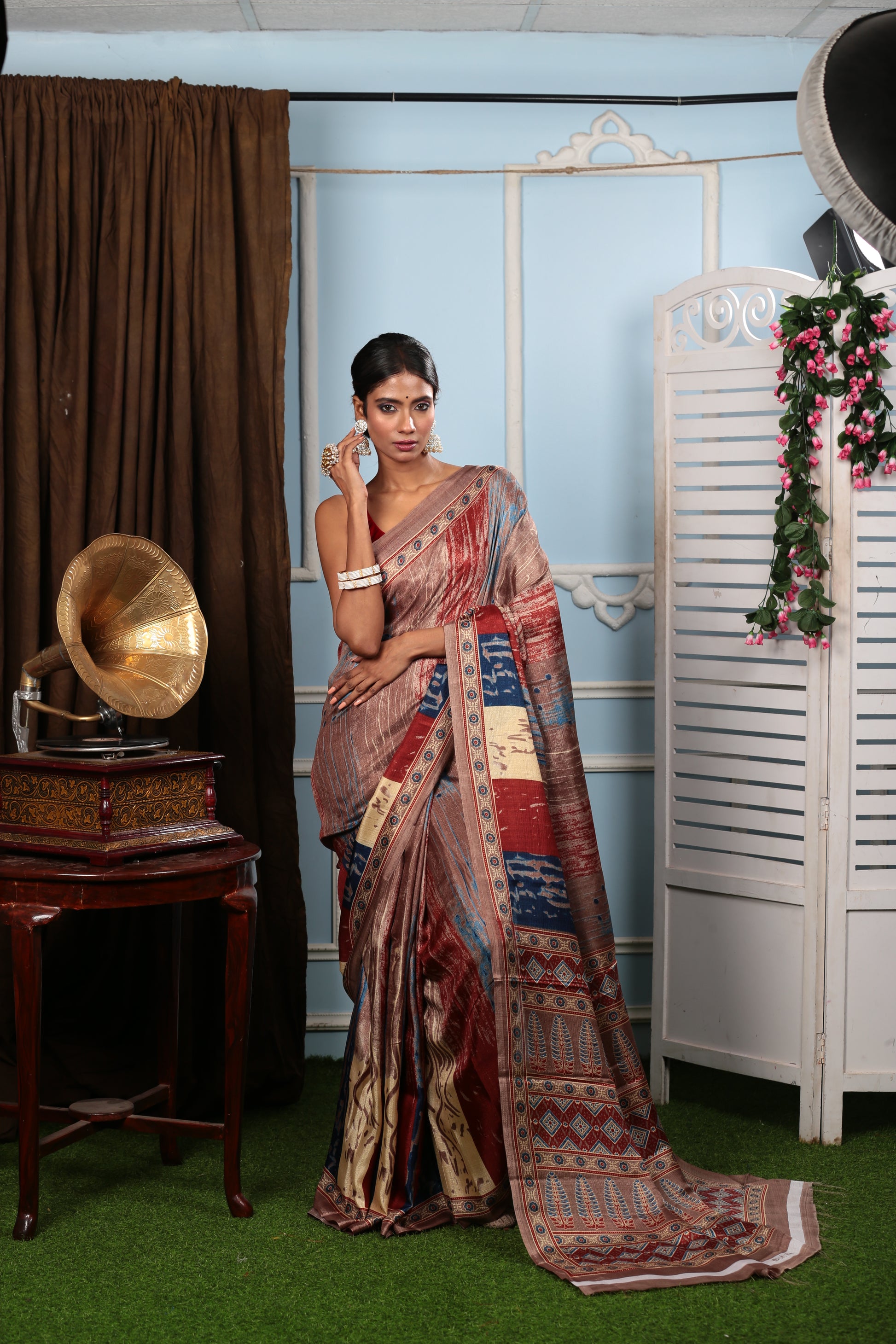 Woman in a brown blend saree with colorful floral pallu, perfect for temple wear. | Urbane Essence