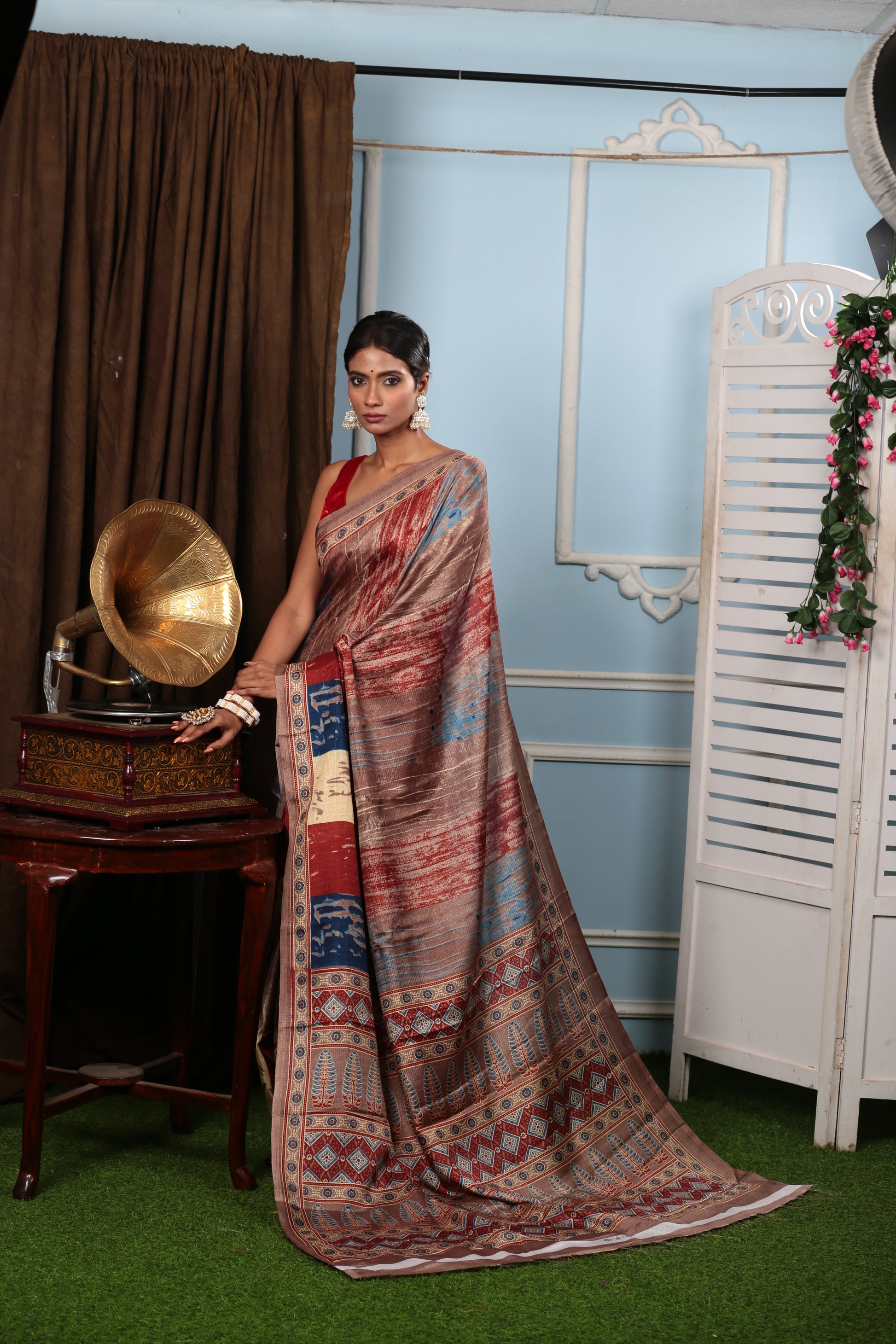 Woman in a brown blend Temple Fabric saree with colorful floral pallu, ideal for temple wear. | Urbane Essence