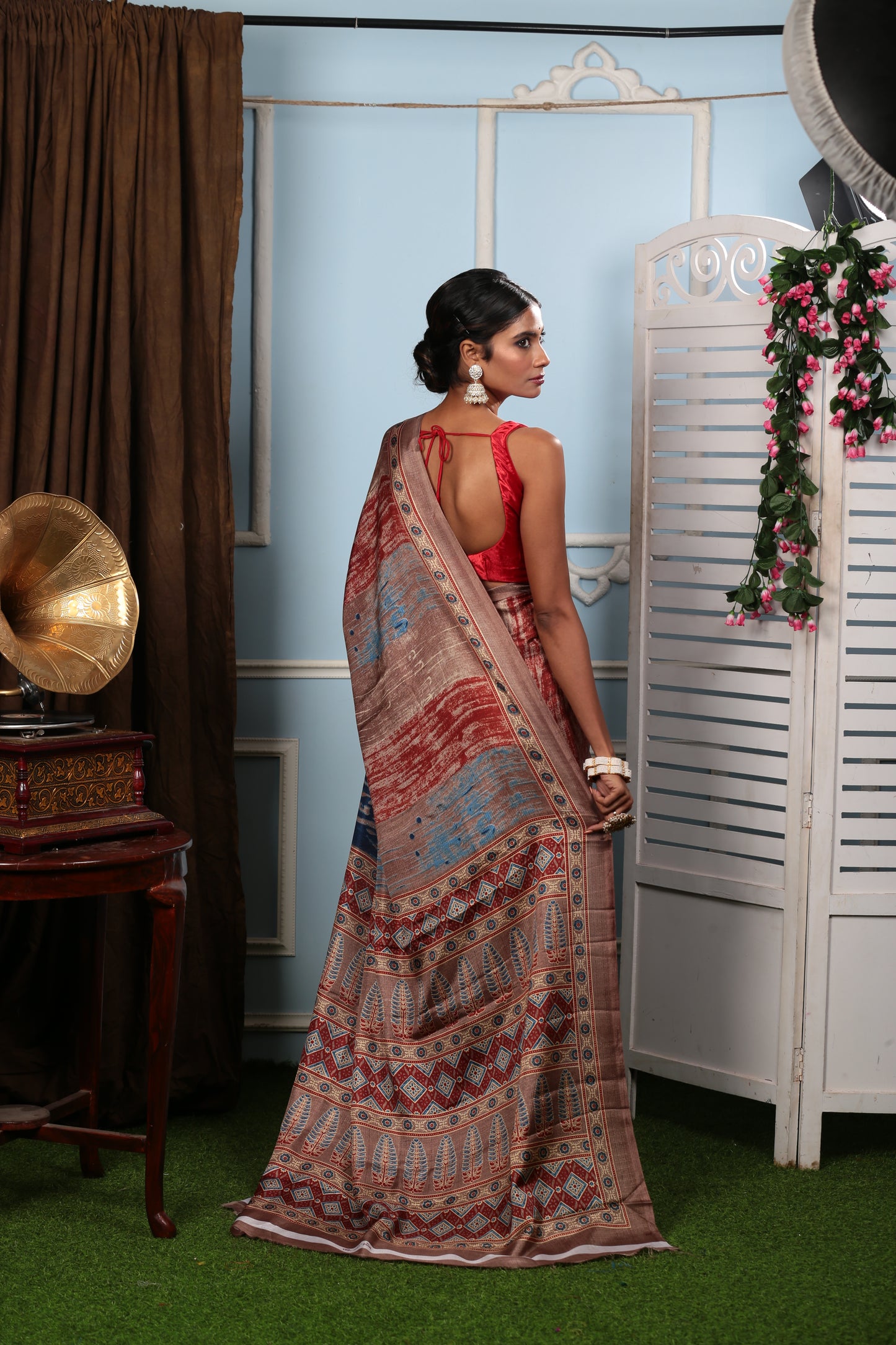 Woman in a brown blend saree with colorful floral pallu, ideal for temple wear. | Urbane Essence