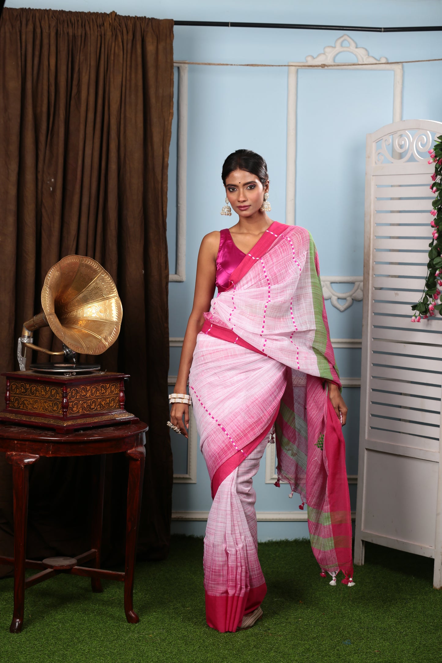Woman in a pink and white Bengal Khadi saree with green accents, perfect for festive wear | Urbane Essence