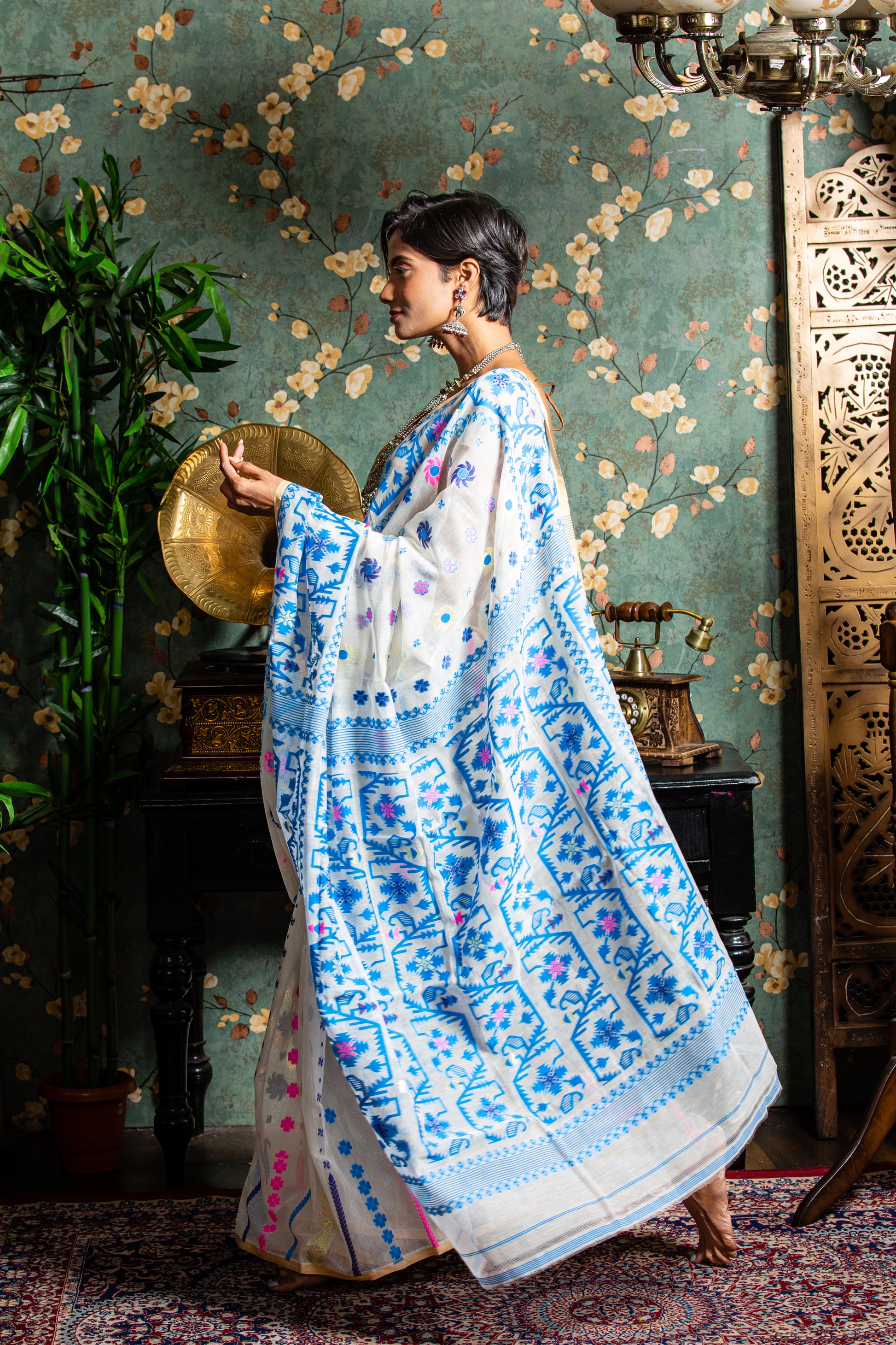 White cotton Jamdani saree with blue and pink floral motifs, ideal for Pujas or work | Urbane Essence