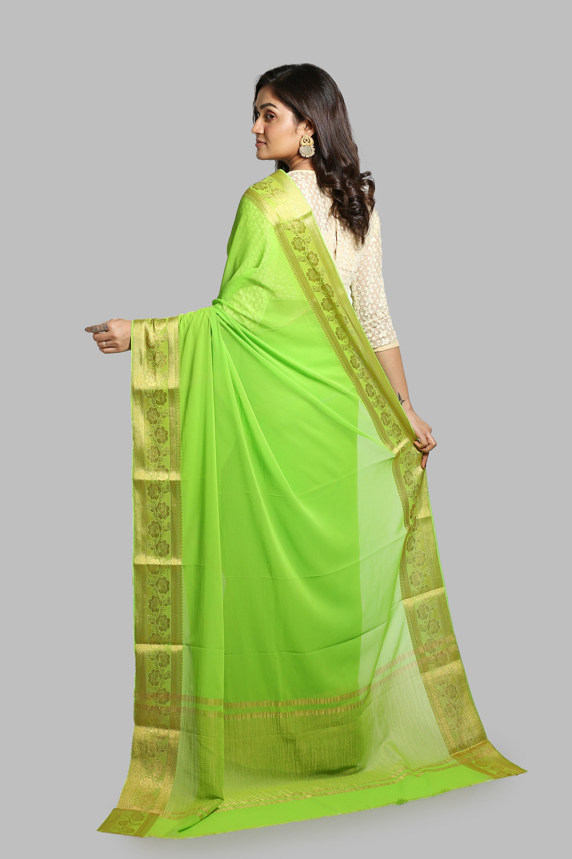 Green chiffon-blend saree with broad golden floral zari border and busy pallu design, perfect for daily wear or special occasions | Urbane Essence