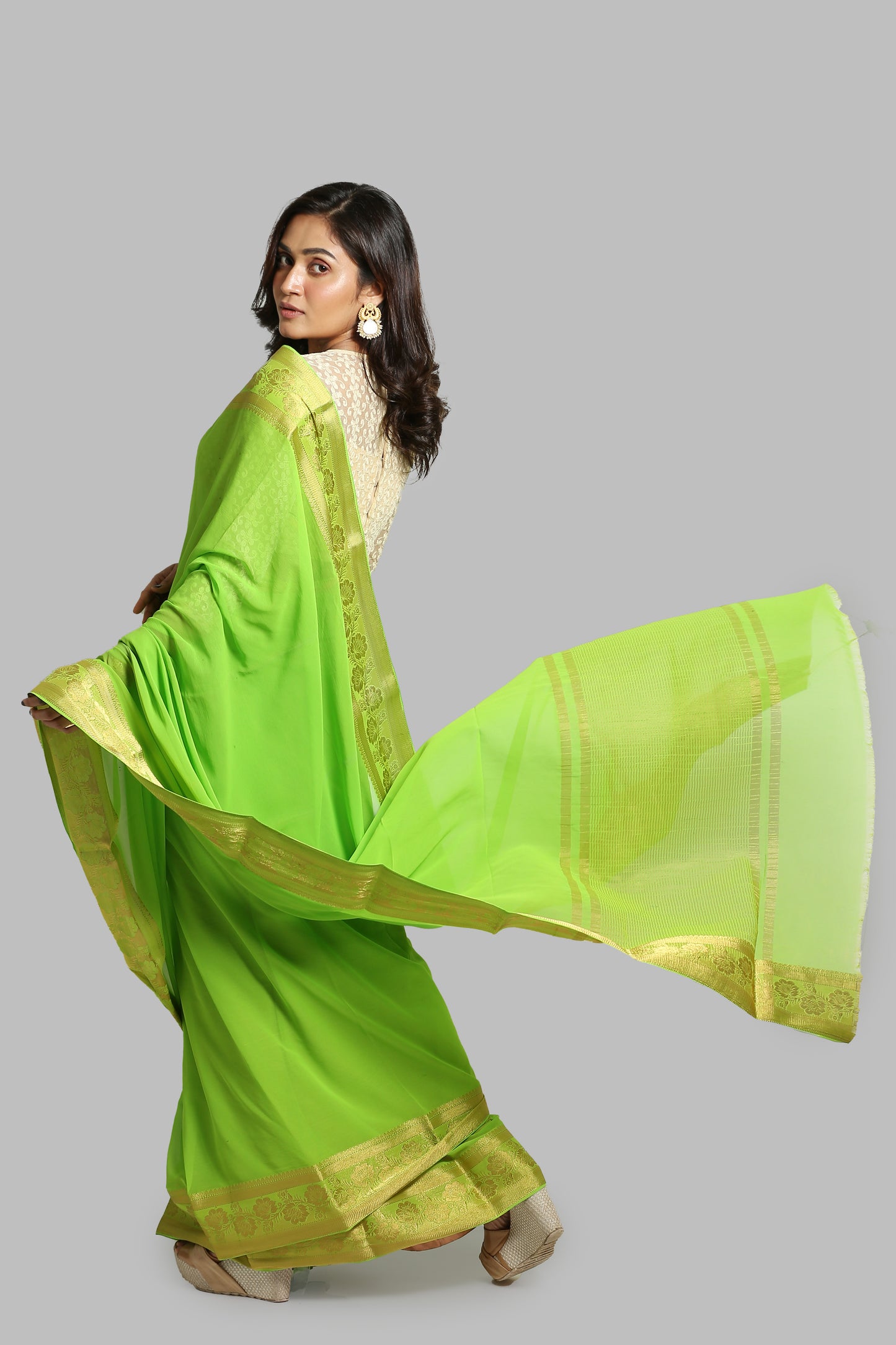 Green chiffon-blend saree with broad golden floral zari border, suitable for festive wear. | Urbane Essence