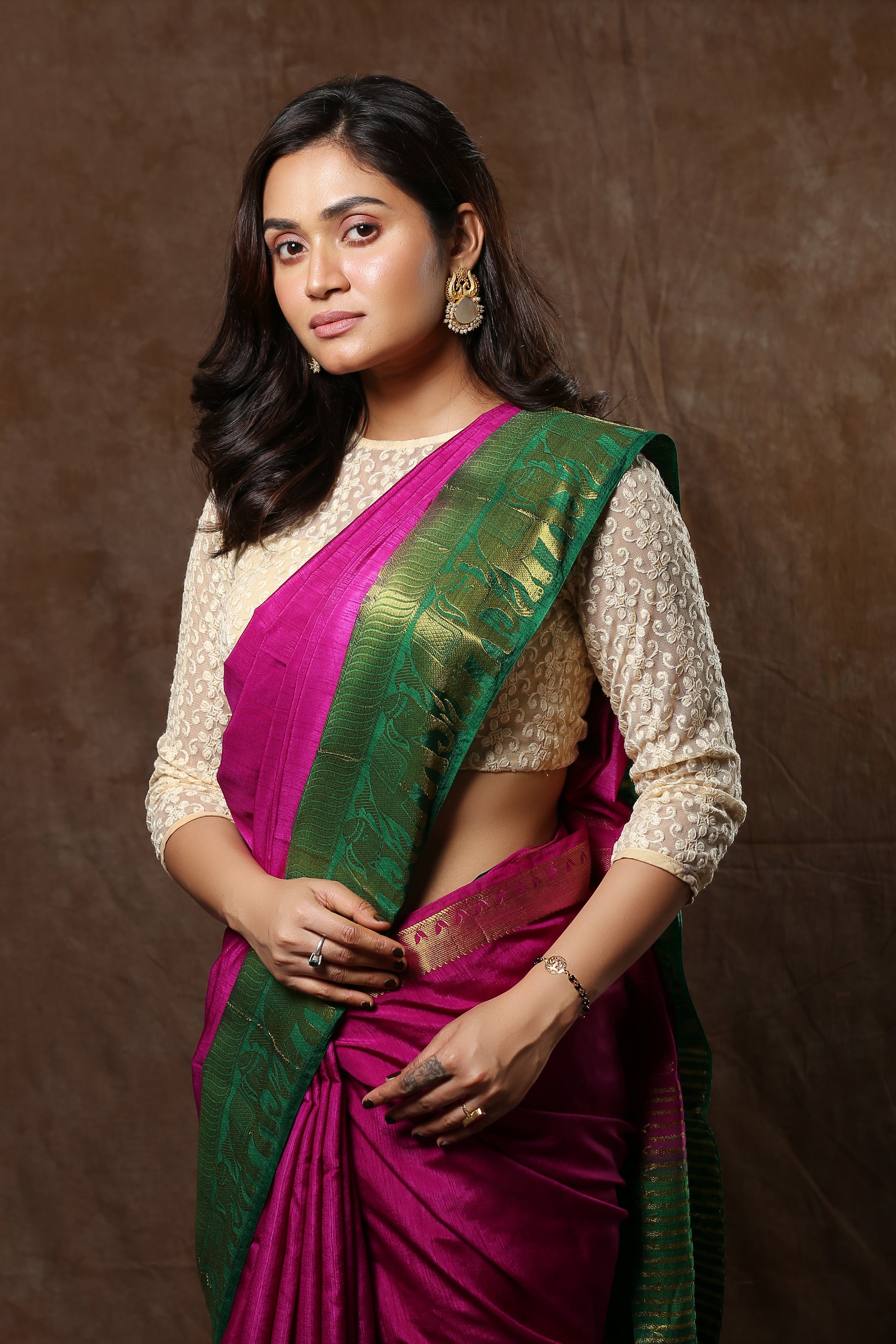 Sun-kissed Rosewood raw silk saree with broad green border and golden zari patterns, perfect for traditional occasions | Urbane Essence