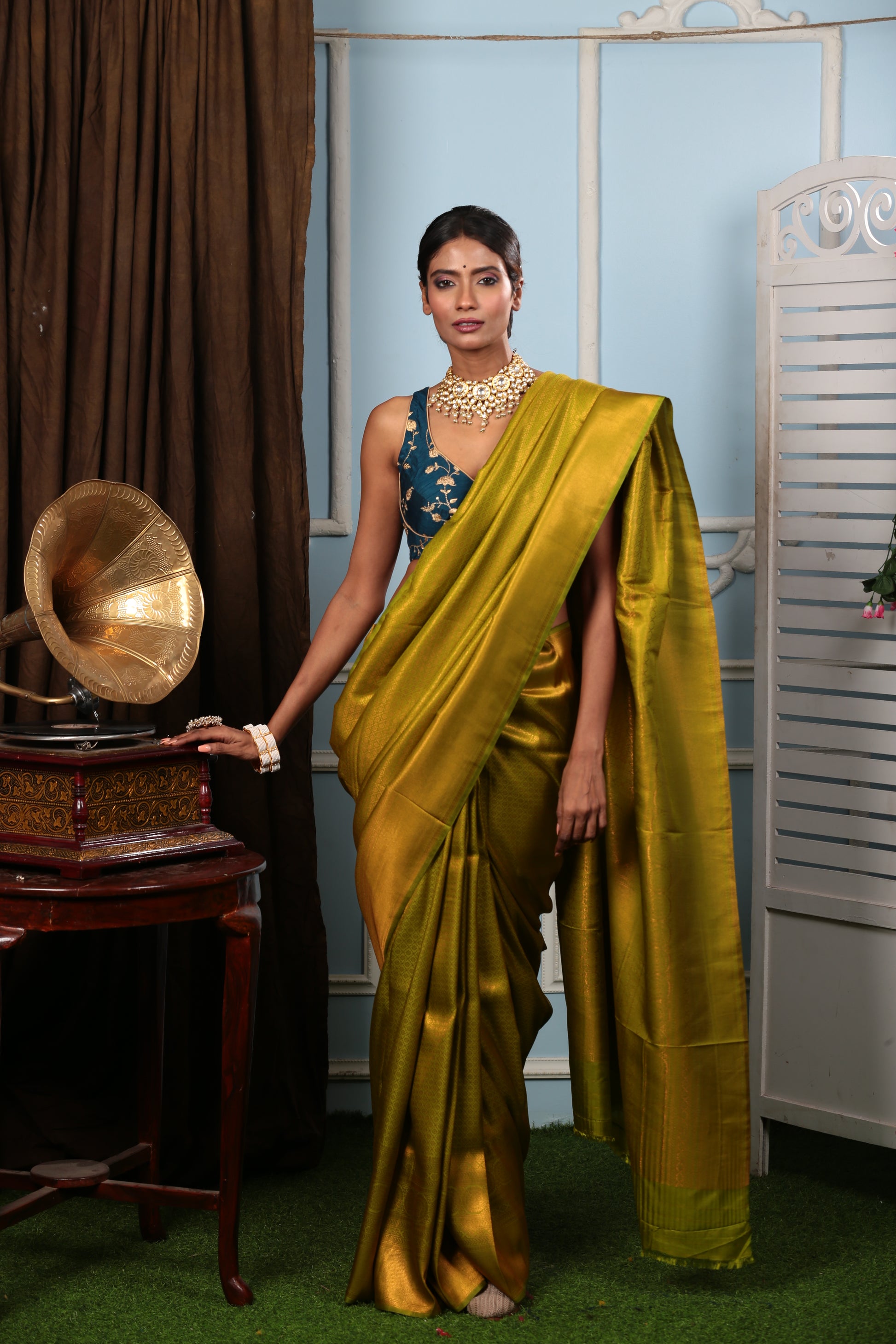 Model in a lustrous copper-green South silk saree, perfect for weddings & celebrations | Urbane Essence